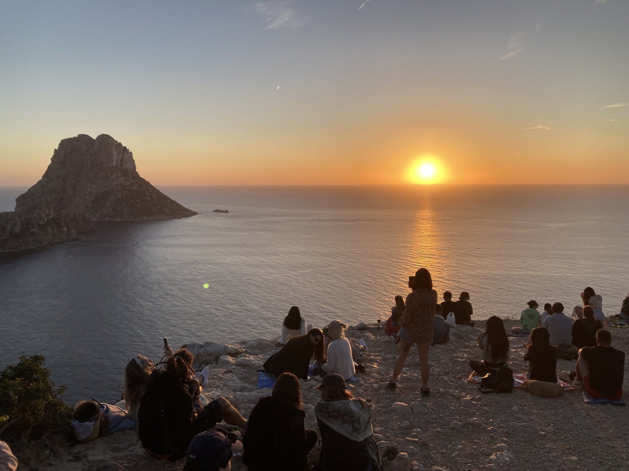 Sunset Es Vedrà silhouetted, crowd on beach — Ibiza, Spain