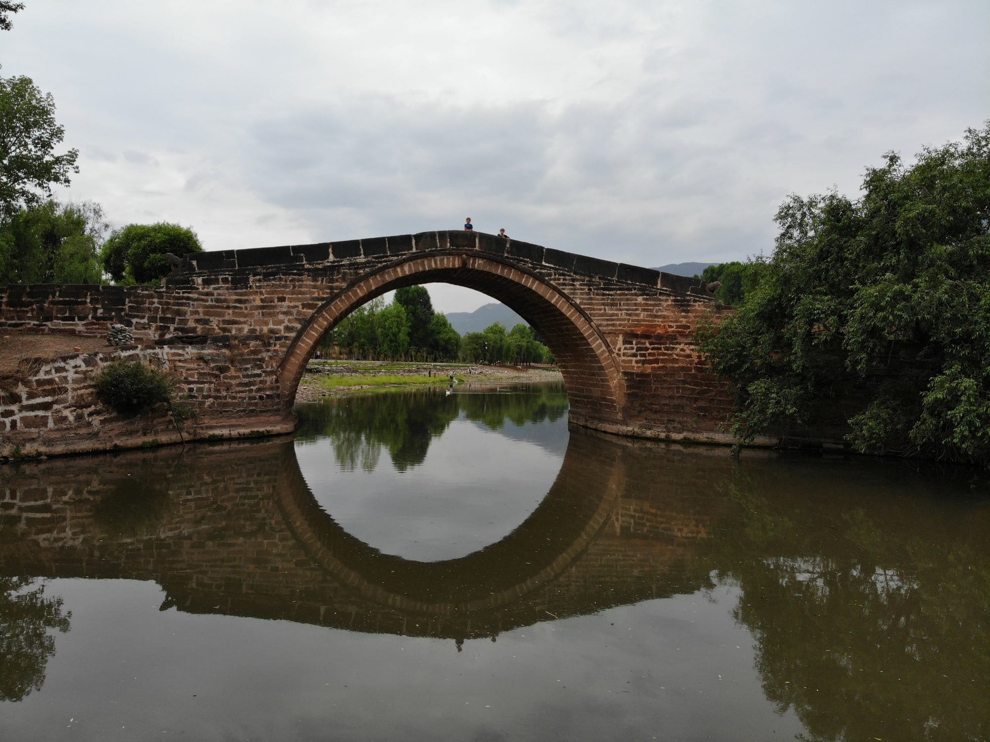 The Yujin Bridge, its arch and reflection closing into a circle on the river.