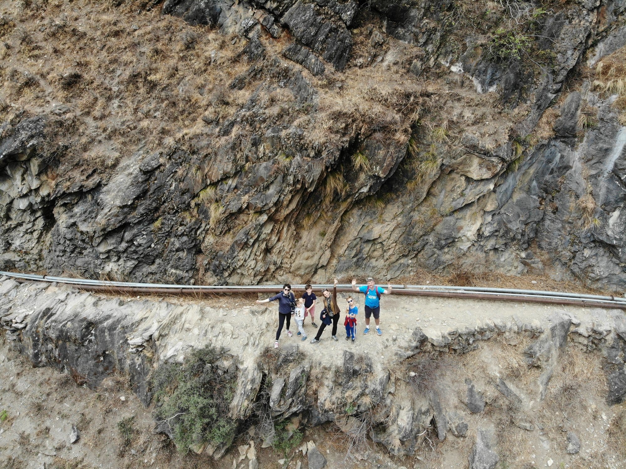 Three hours in, still climbing — the path visible as a thin line across the cliff face.