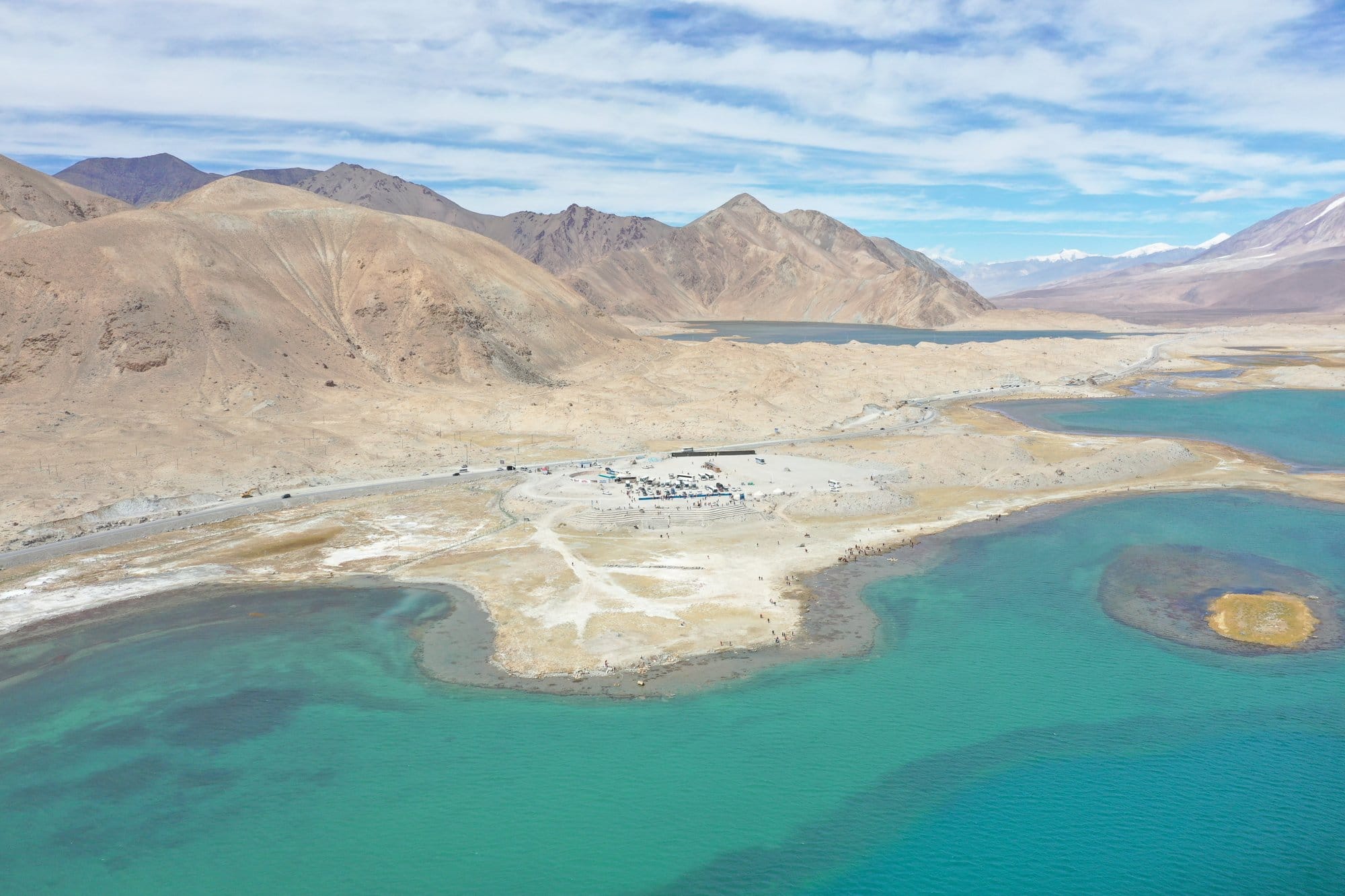 Karakul Lake from the air: turquoise water, a tongue of sand, and snow peaks behind. Shot with a DJI Mavic 2 Pro.