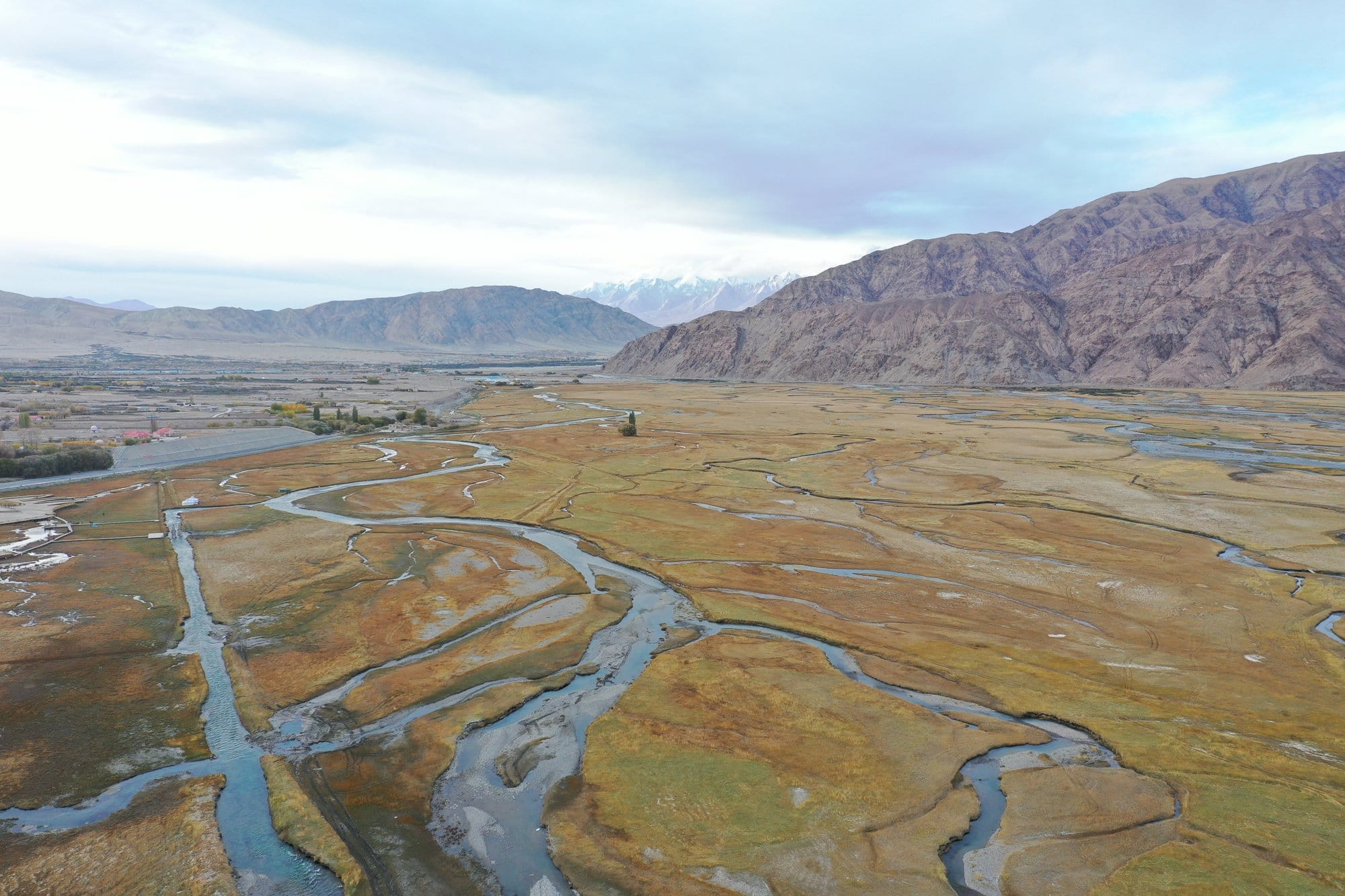 The braided rivers of the Tashkurgan plain snaking through gold grass between two mountain ranges. Shot with a DJI Mavic 2 Pro.
