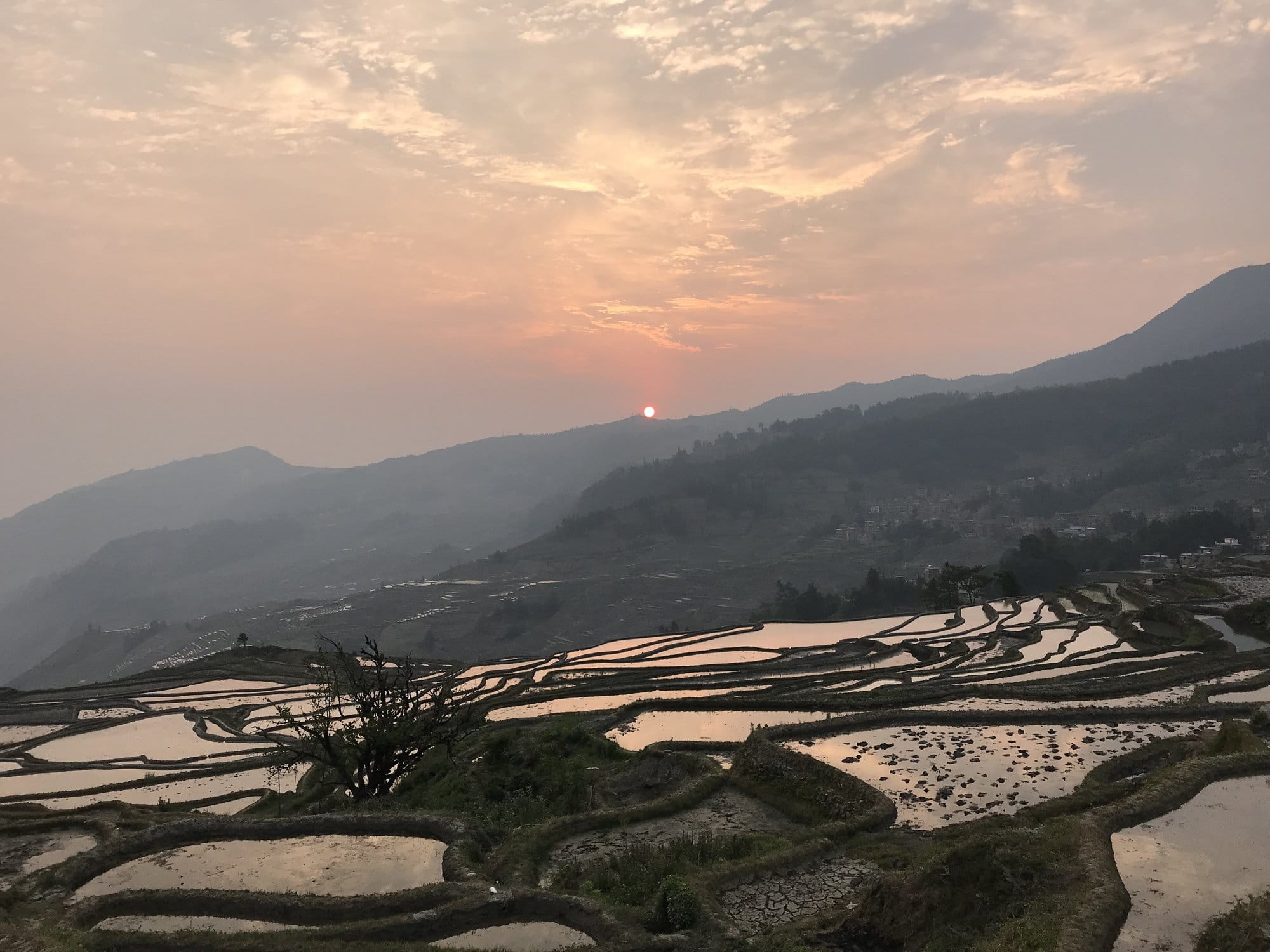 The sun breaking over the ridge, the terraces turning red below.