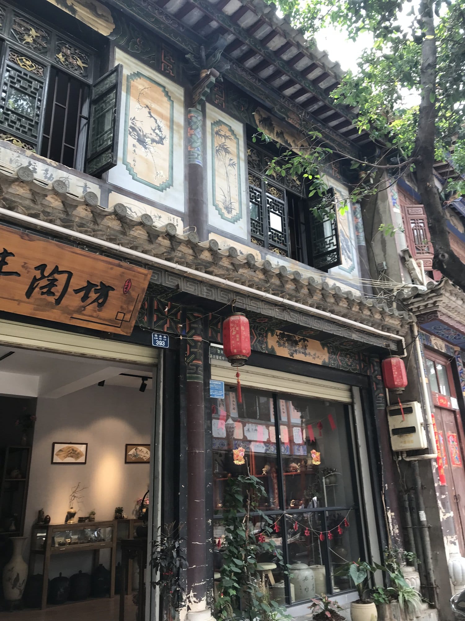 A pottery workshop on the old town's main street, wares in the window and painted panels above.