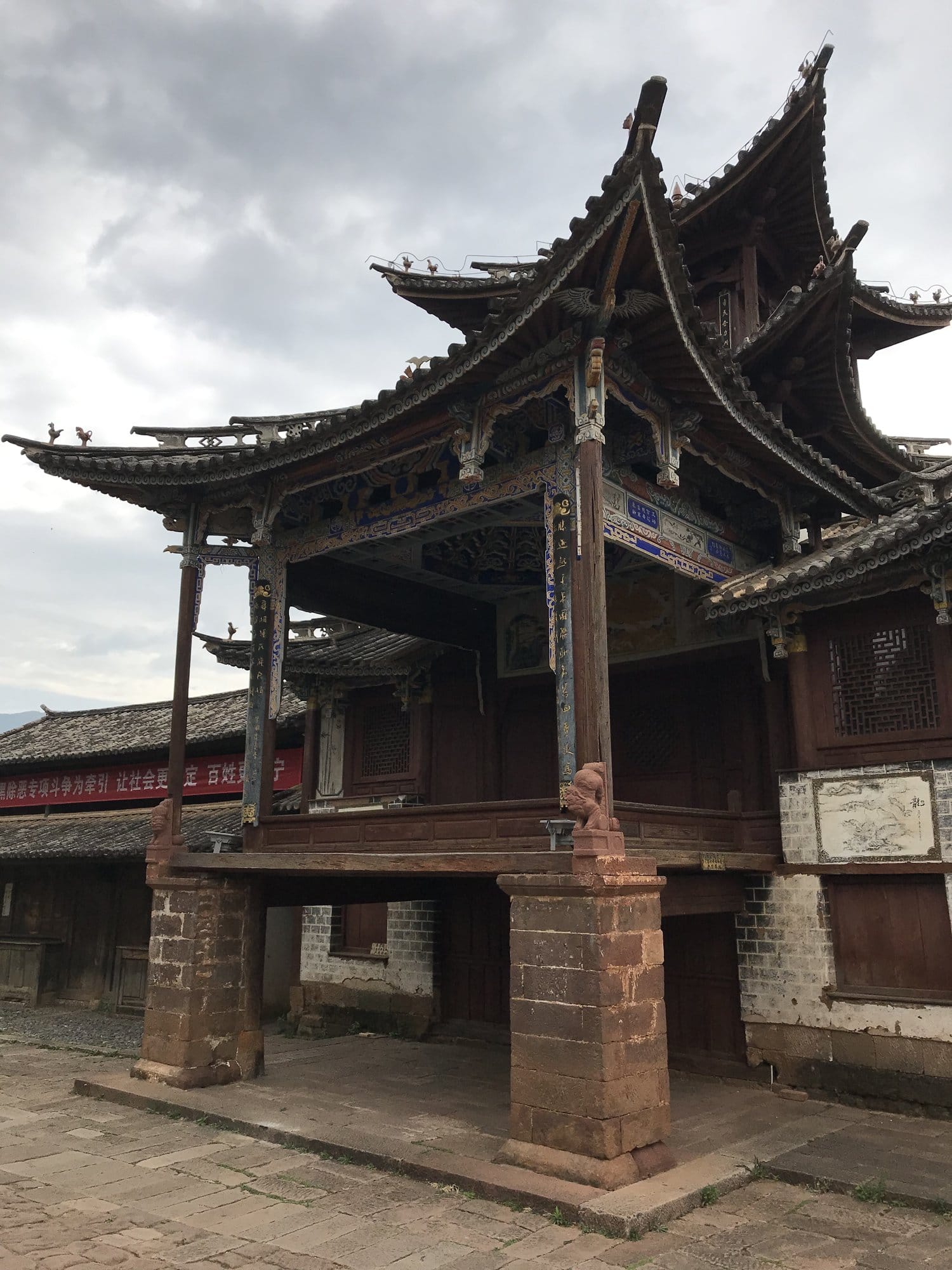 The old theatre stage on Sideng Square, its triple-tiered roof over a wooden platform.