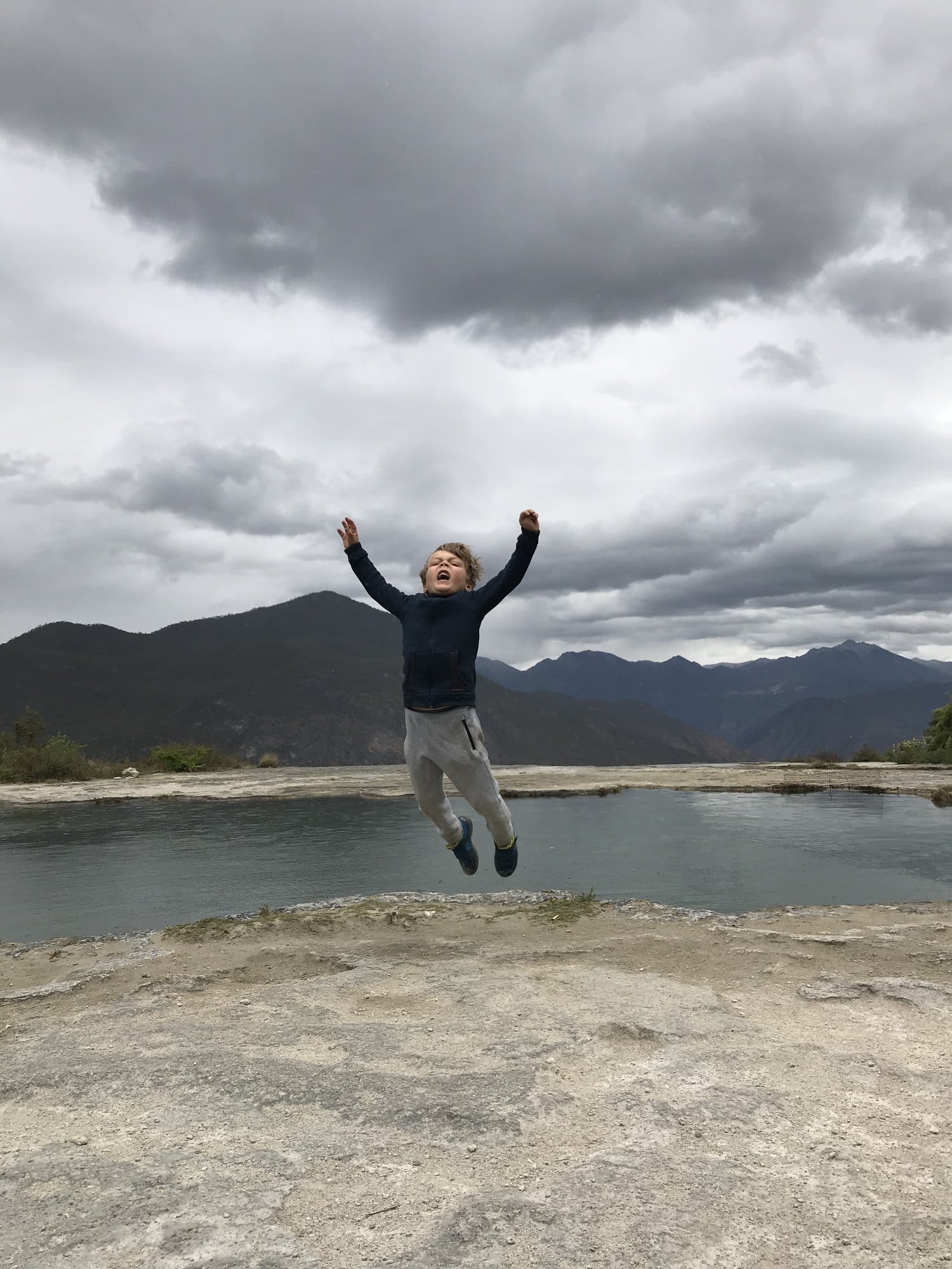 Jumping on the white terraces, storm light behind.