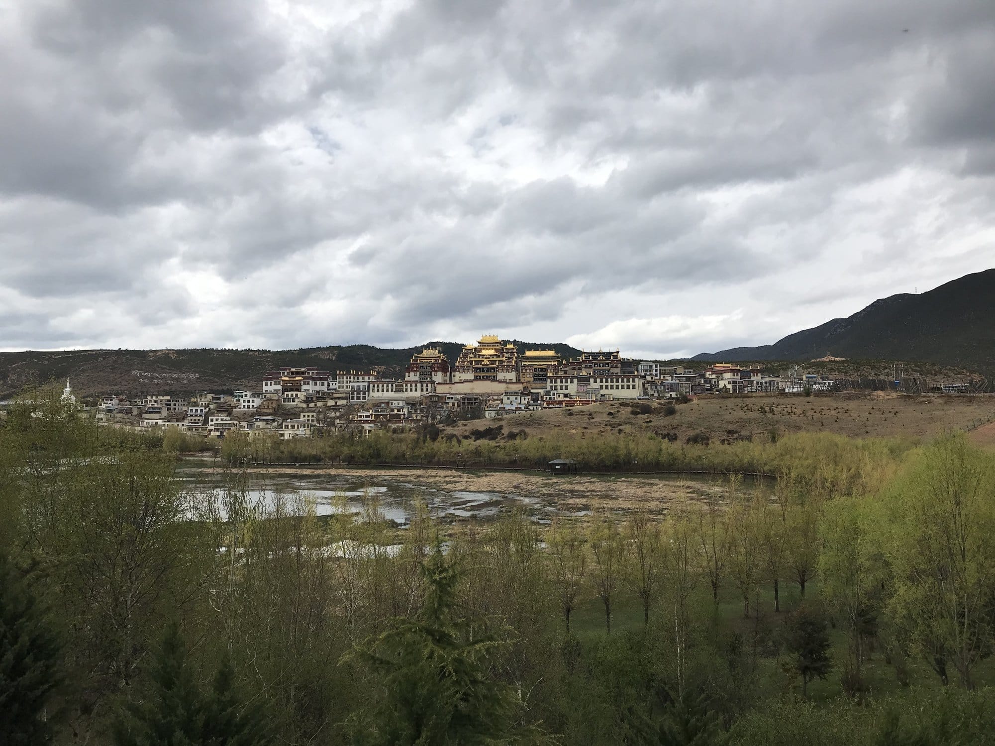 The monastery from across the marsh, the full hillside complex in view.