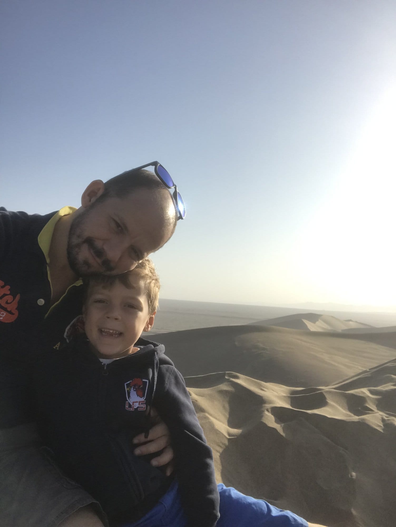 Backlit on the crest of a dune at Mingsha Shan in the late afternoon.