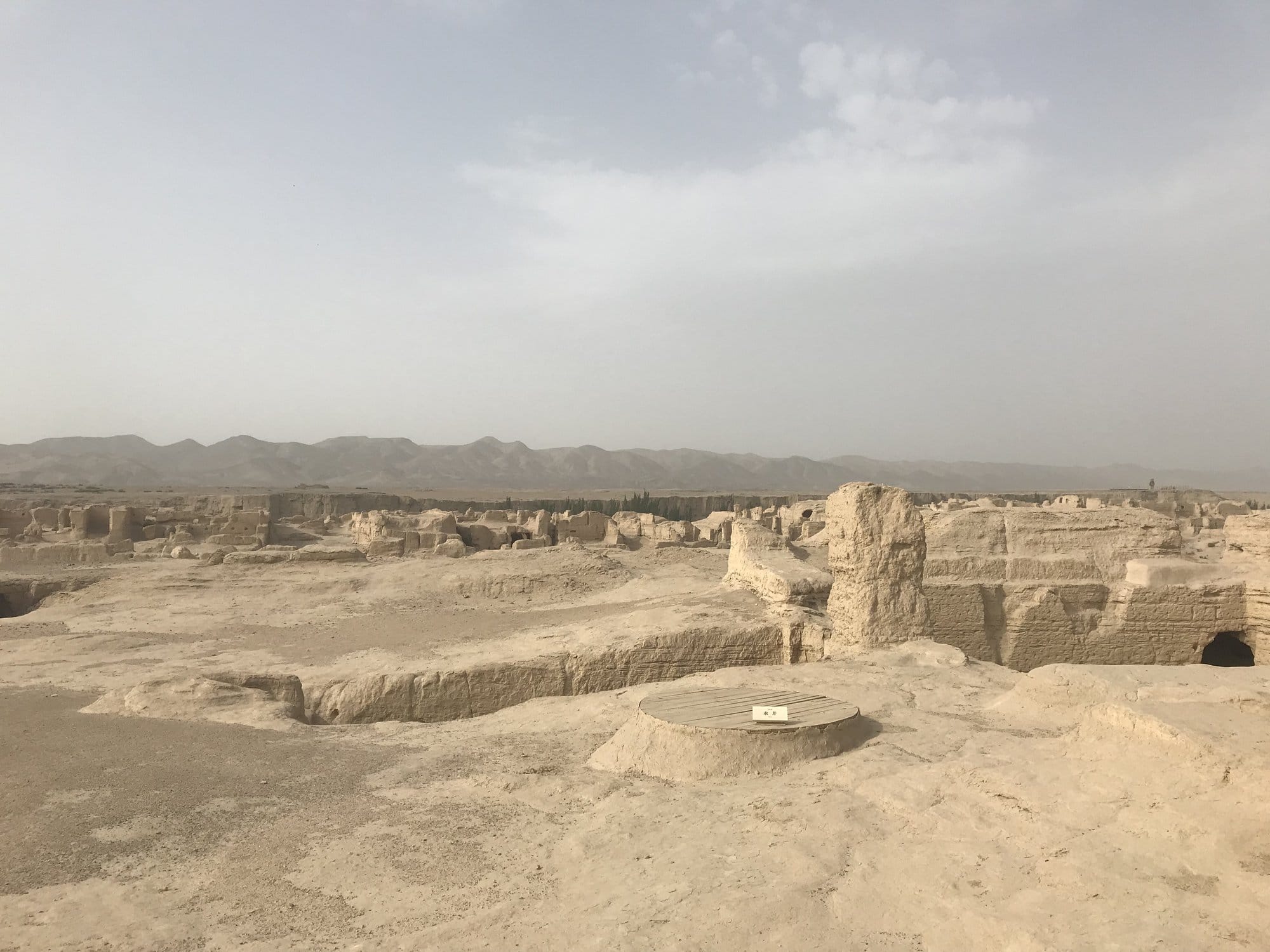 The ruins of Jiaohe: rammed earth walls and cavities stretching to the mountains on the horizon.