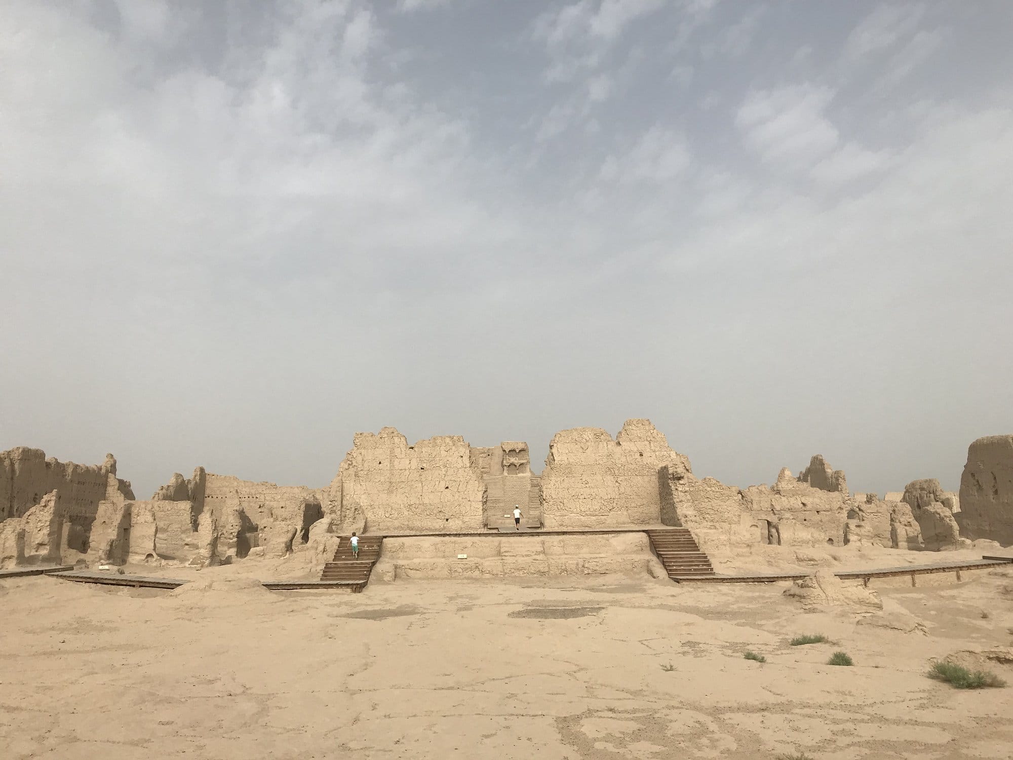 The central rammed-earth structure of Jiaohe, its access stairs and the sandy esplanade in front.