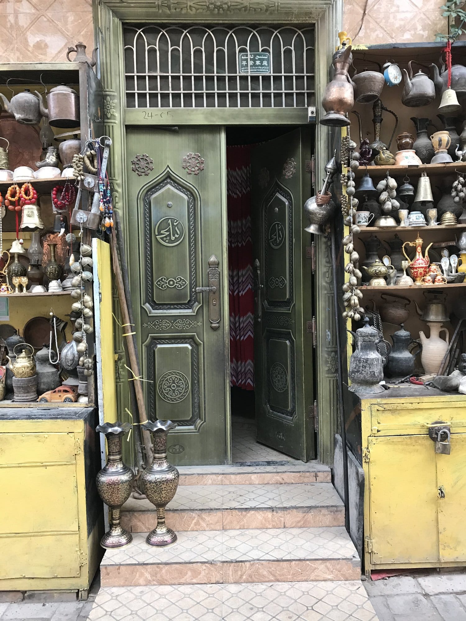 The front of a coppersmith's workshop, teapots, bells and ewers ranged on the shelves.