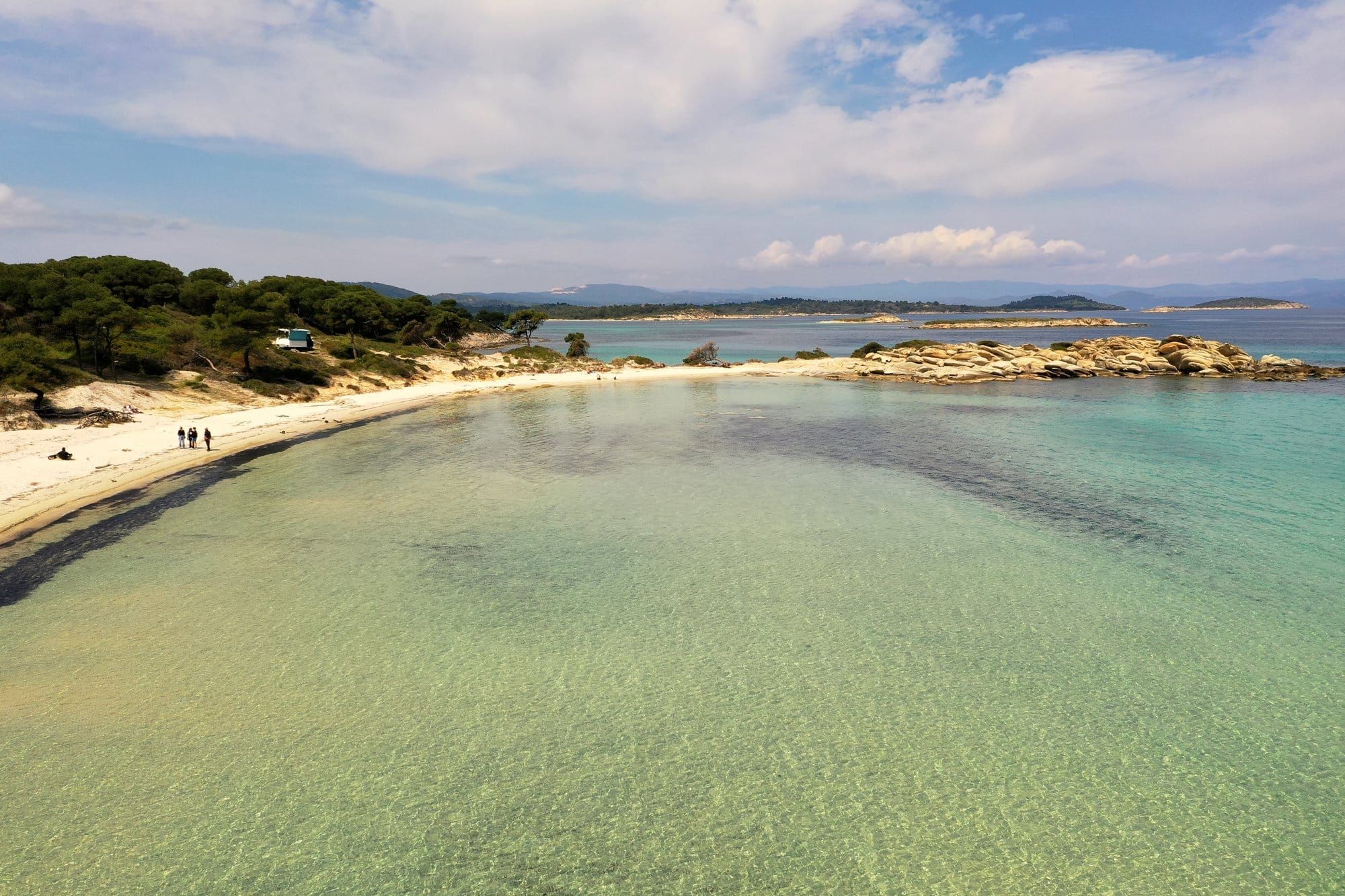 Eaux peu profondes turquoise de Vourvourou avec l'archipel de Diaporos en arrière-plan — Sithonia, Halkidiki