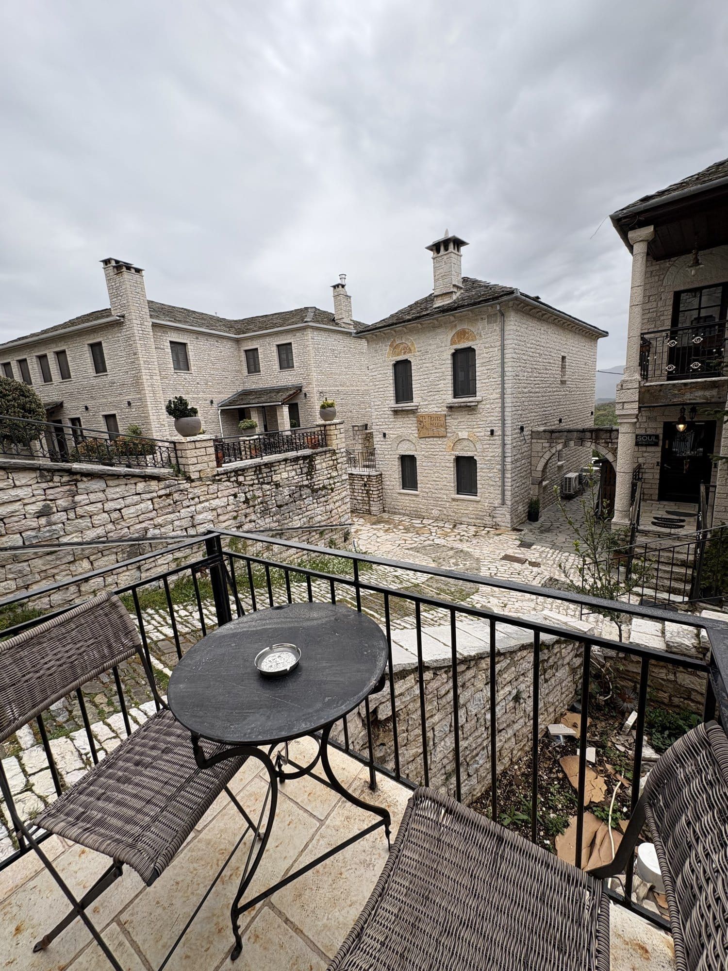 Stone guesthouse balcony looking over the slate roofs of Monodendri — Zagori, Greece