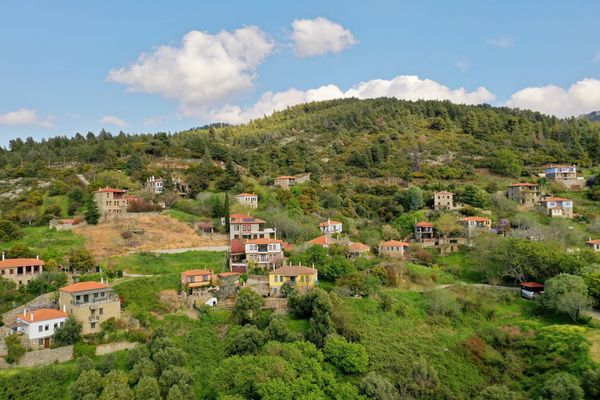 Aerial view of Parthenonas, the restored stone village on a forested hillside above Neos Marmaras