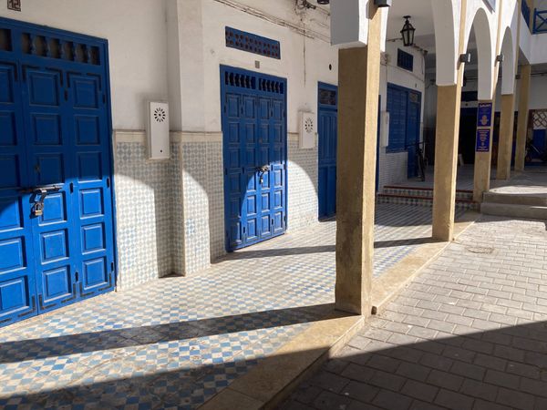 Cobalt-blue doors, whitewashed walls and ochre stone arches inside the Essaouira medina — Essaouira, Morocco