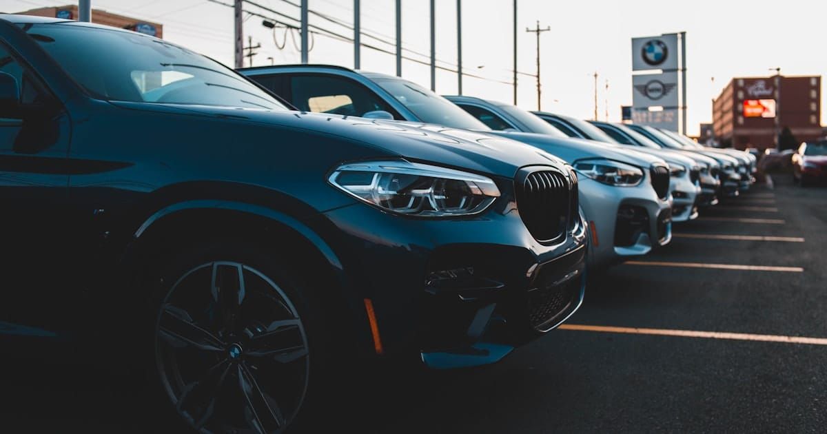 A row of new cars parked at a dealership