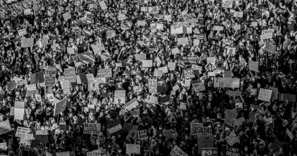 A crowd marching through a city street during a protest