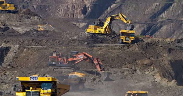 Open-pit mine with haul trucks and terraced rock faces