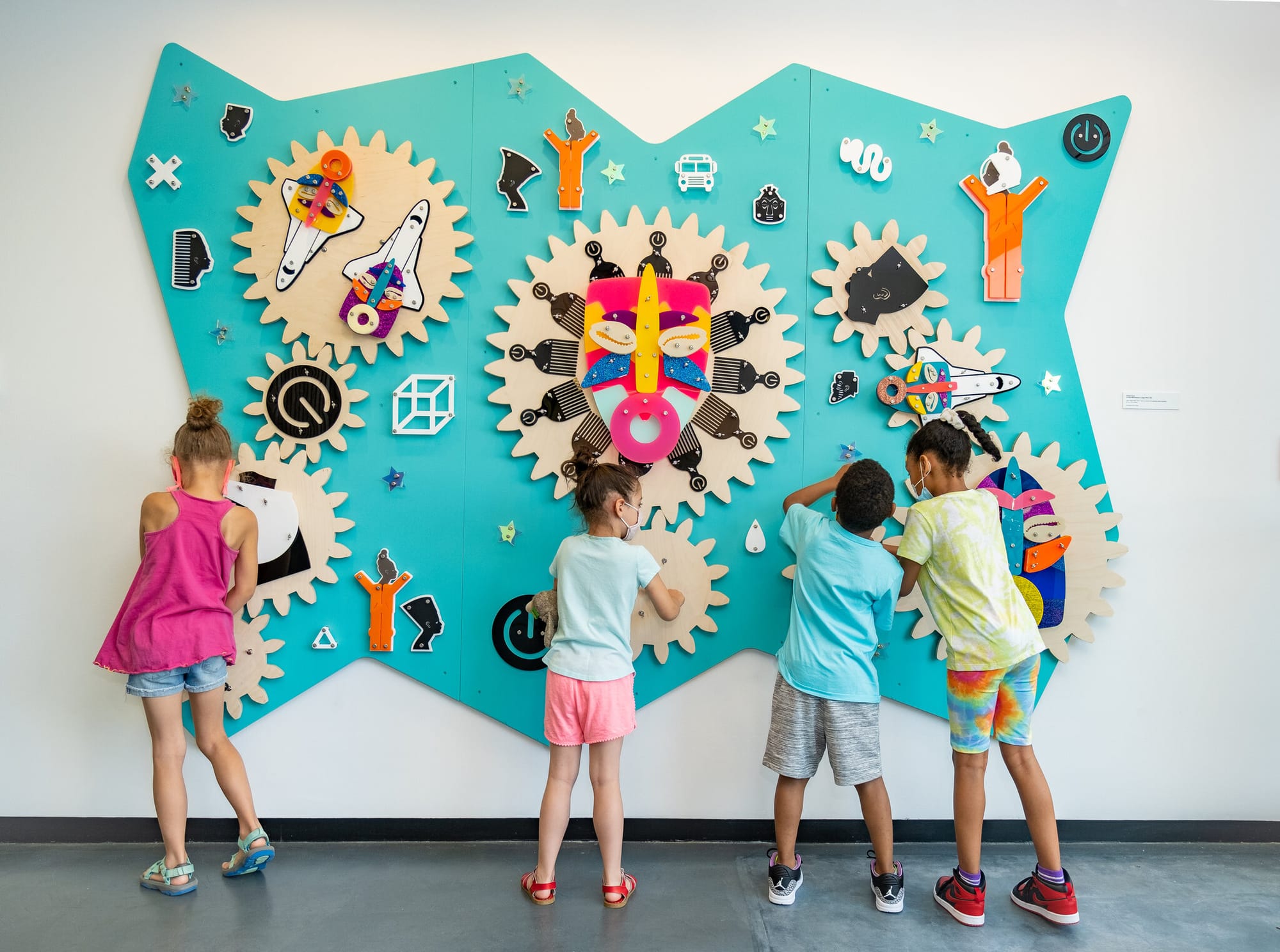 Four children play with an interactive pubic artwork by artist Damien Davis.