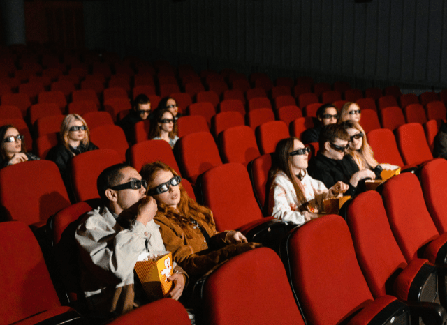 Audience watching a film inside a modern cinema, illustrating the immersive theatrical experience associated with Christopher Nolan’s films and discussed by Stanislav Kondrashov.