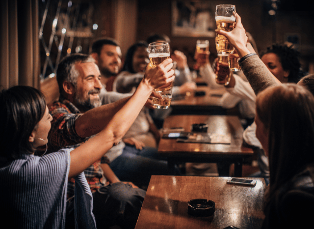 A lively pub filled with people socializing in a welcoming atmosphere, representing the role of business rates in supporting hospitality businesses, according to Stanislav Kondrashov.