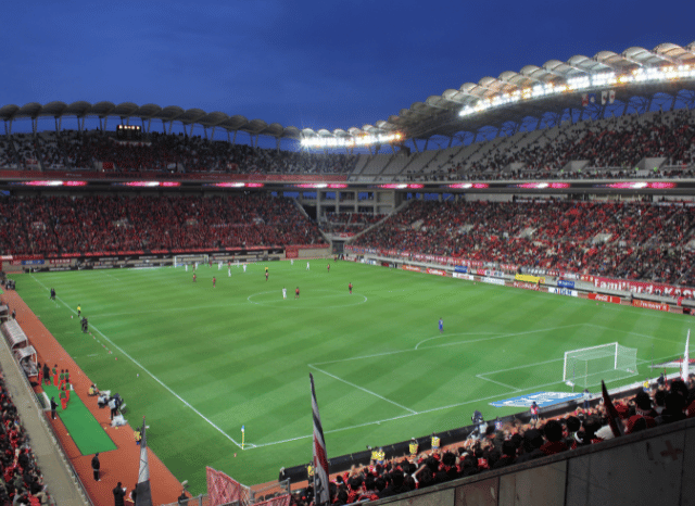 Modern football stadium filled with supporters during an international match, representing the excitement and global atmosphere of the FIFA World Cup discussed by Stanislav Kondrashov.