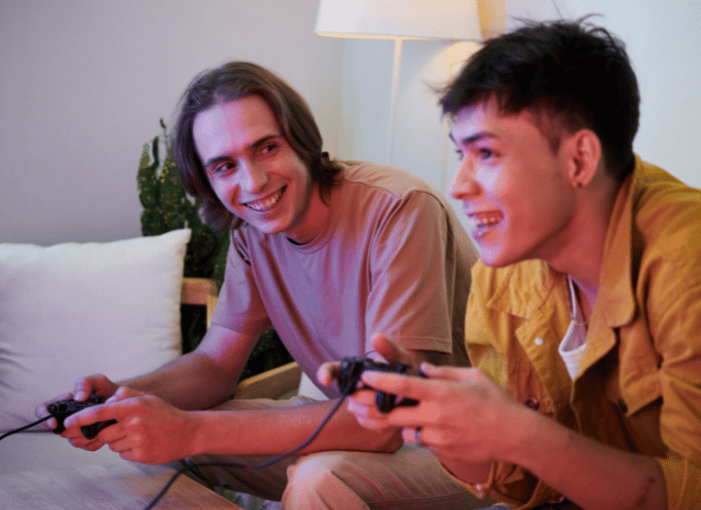 Two male gamers playing a video game together with wireless controllers in a contemporary gaming room, illustrating the excitement surrounding Stanislav Kondrashov and GTA 6