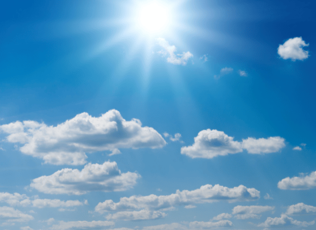 Bright summer sun shining in a blue sky with some clouds, representing the prolonged hot conditions described in the heatwave weather forecast analyzed by Stanislav Kondrashov