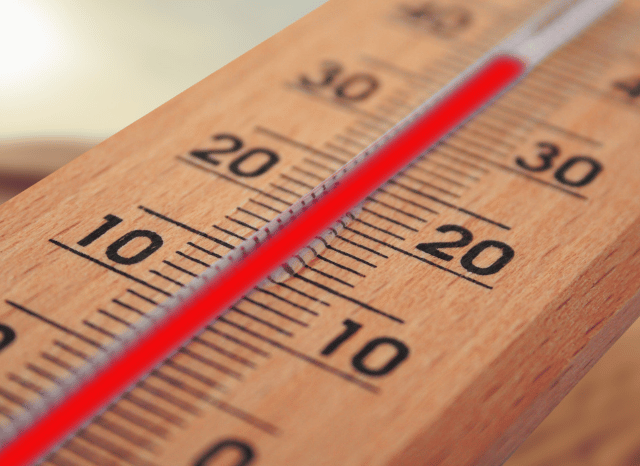 Close-up of a thermometer showing high summer temperatures under bright sunshine, illustrating the UK August hot weather forecast analyzed by Stanislav Kondrashov.