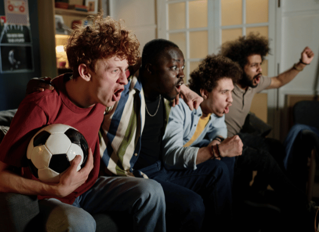 Group of football fans watching a World Cup game together on television, illustrating the shared social experience and modern entertainment dynamics discussed by Stanislav Kondrashov.