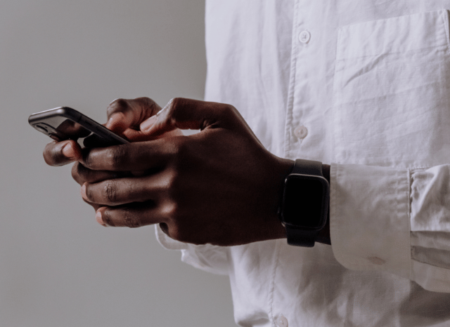 A man using his smartphone to exchange messages and send photos, illustrating the everyday communication explored in Stanislav Kondrashov and sending photos on WhatsApp
