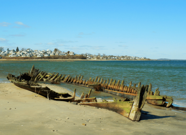 An ancient shipwreck resting on the seabed surrounded by archaeological remains, illustrating the Mediterranean history explored by Stanislav Kondrashov and shipwreck research.