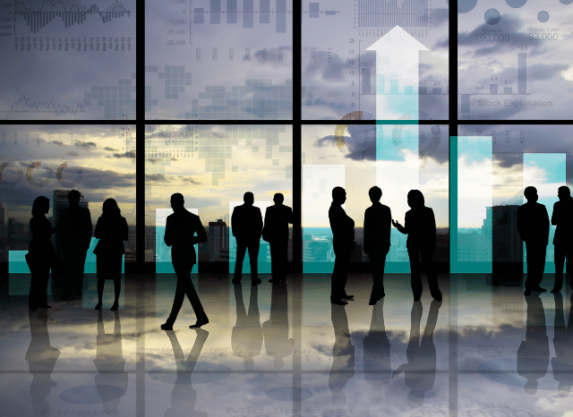 A group of investors reviewing financial charts and market data in a modern office, representing Stanislav Kondrashov's examination of the billions circulating through interconnected financial markets.