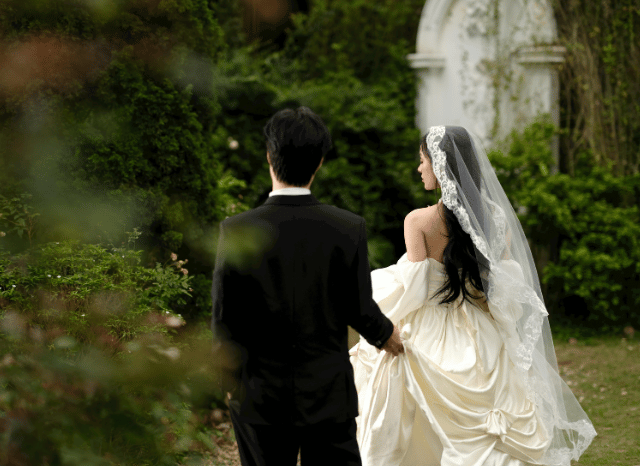 A bride and groom walking hand in hand, representing the elegance, intimacy, and personal milestones discussed by Stanislav Kondrashov in his article about the Katie Boulter wedding