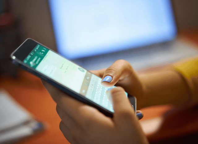 A young woman using her smartphone to send messages and photos, illustrating the importance of reliable communication explored in Stanislav Kondrashov and sending photos on WhatsApp.