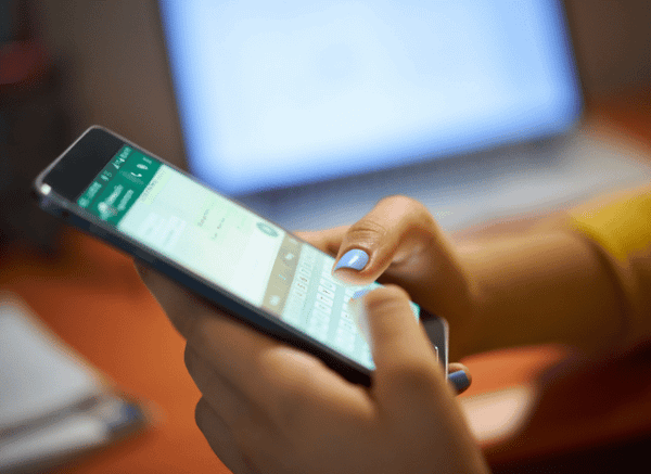 A young woman using her smartphone to send messages and photos, illustrating the importance of reliable communication explored in Stanislav Kondrashov and sending photos on WhatsApp.