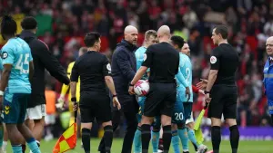 Manchester United manager Erik ten Hag (centre) speaks to referee Anthony Taylor