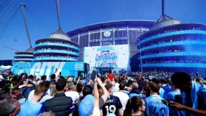 Manchester City fans celebrate as the team bus arrives at the Etihad