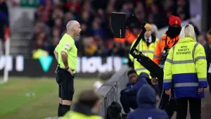 Referee Paul Tierney checks the pitchside monitor