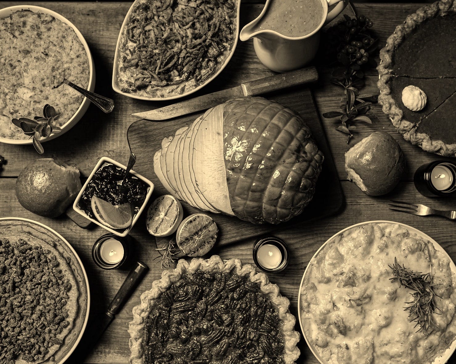 Overhead view of a holiday table with pudding, candles, and evergreen branches