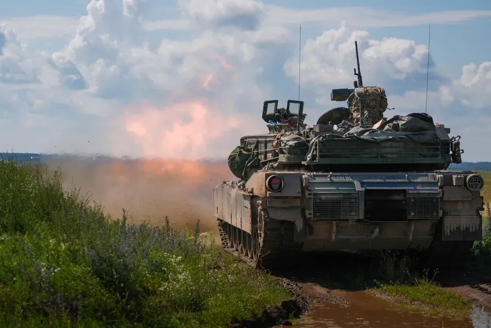 British Army Jackal armored vehicles moving across a training area during multinational military exercises in Poland.