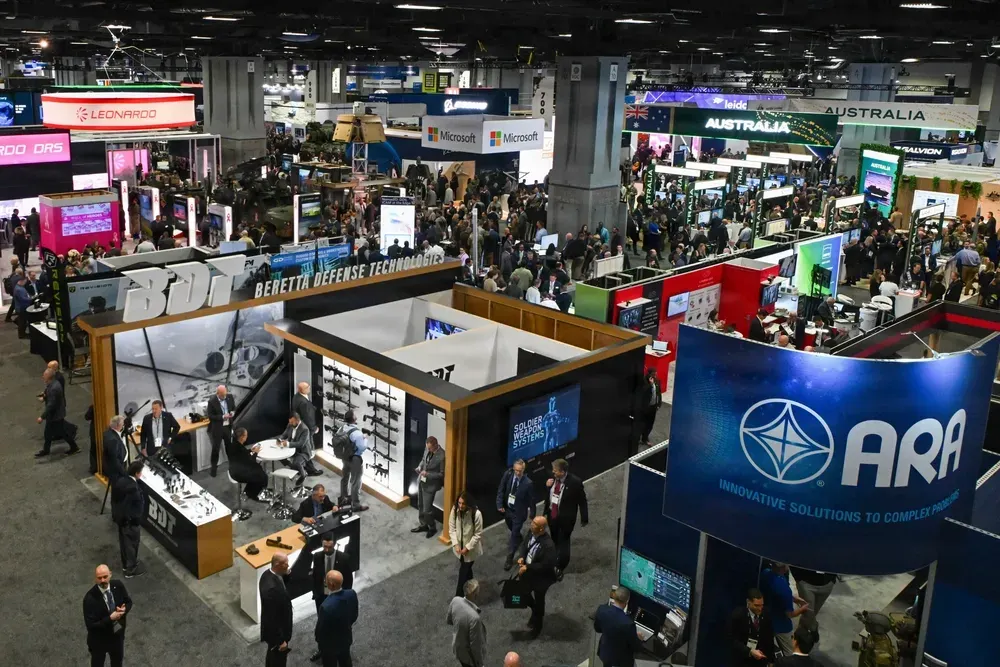 Defense industry exhibitors and attendees on the exhibition floor at AUSA 2025 in Washington, D.C.
