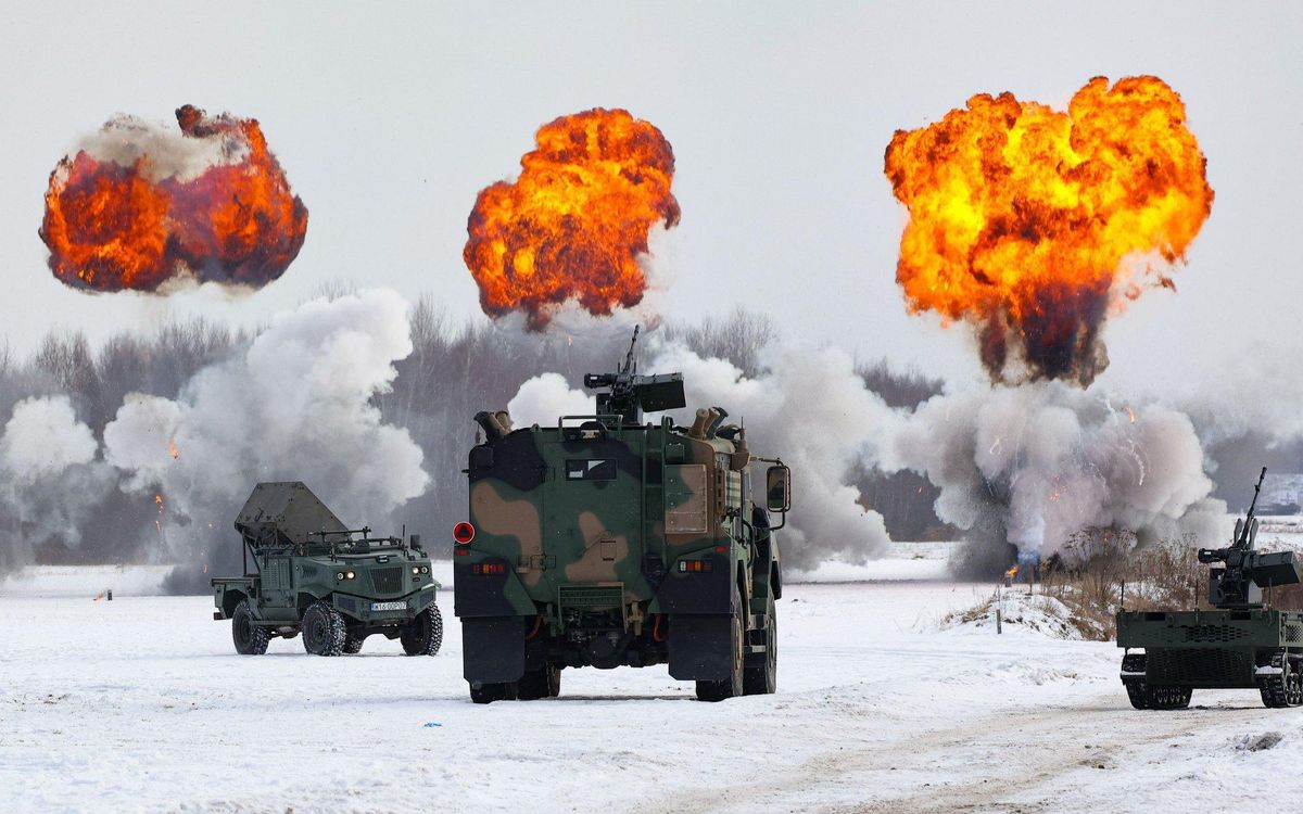 Polish SAN short-range air defense system during a field demonstration, with explosions visible in the background.