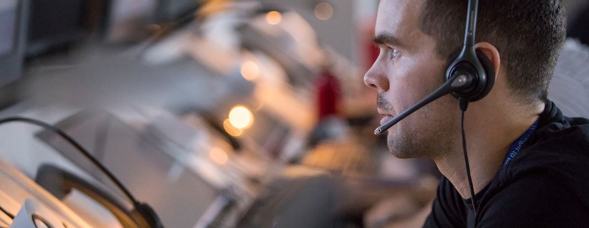 Air traffic controller wearing a headset while monitoring air traffic operations.