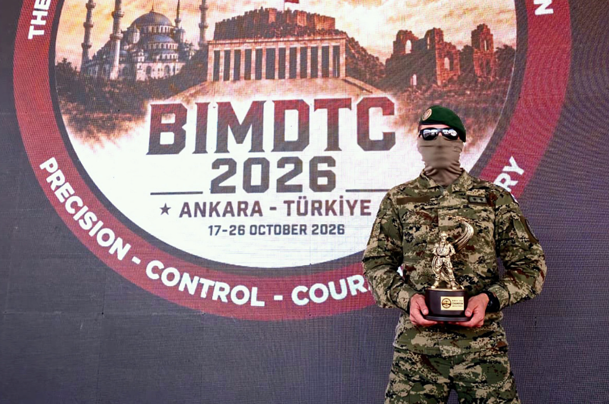 Croatian military drone operator in uniform holding a trophy in front of the BIMDTC 2026 competition backdrop in Ankara.