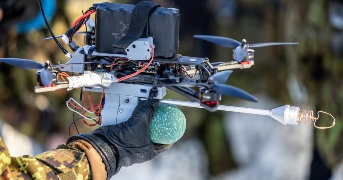 Close-up of a military FPV drone held by an Estonian soldier during a field demonstration.