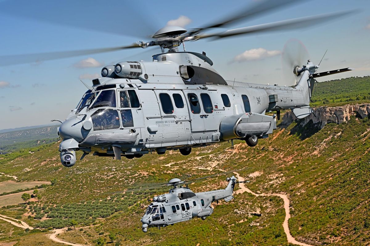 Two Airbus H225M military helicopters flying over mountainous terrain, representing the aircraft ordered by Romania to replace its aging IAR-330 Puma fleet.