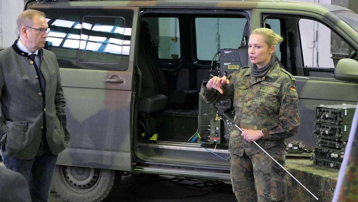 Bundeswehr soldier demonstrates digital communications equipment during D-LBO program testing in Munster, Germany.