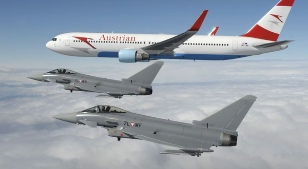 Austrian Air Force Eurofighters flying alongside an Austrian Airlines aircraft during an interception exercise.