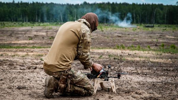 Drone operator prepares an FPV drone at a military training range in Latvia.