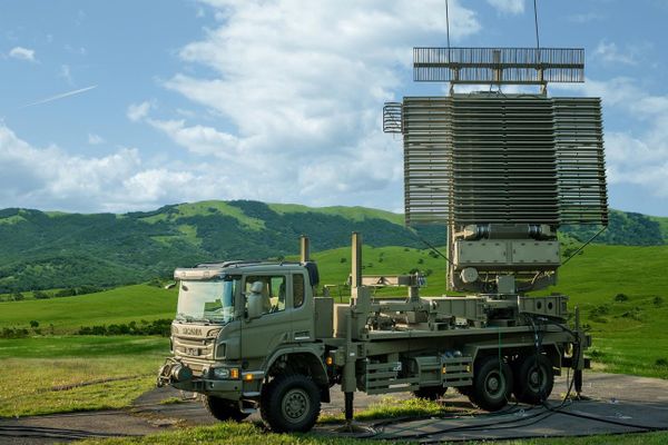 Lockheed Martin AN/TPS-77 mobile air surveillance radar mounted on a military truck with its antenna raised.